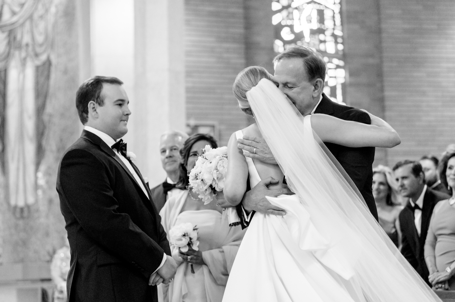 father of the bride hugging her as he hands her off to the groom 