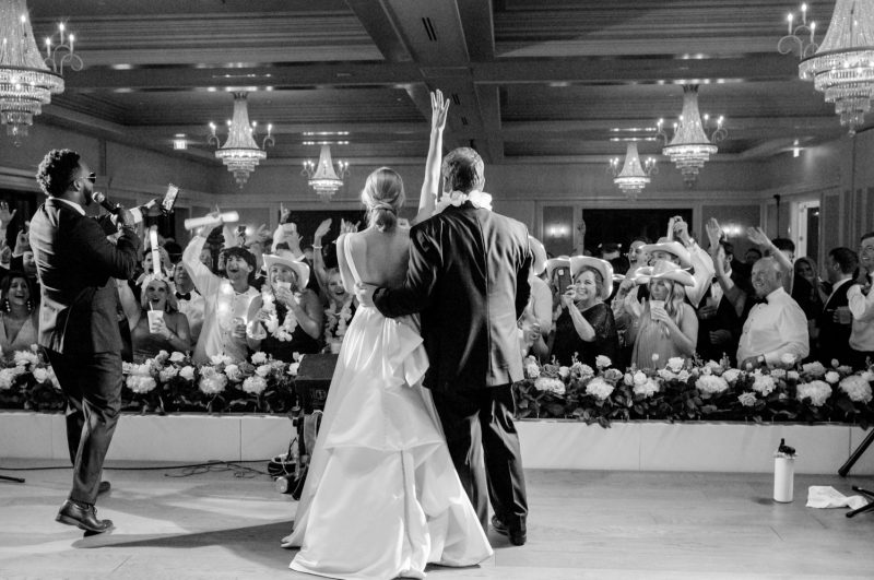 Black-and-white photo of the bride and groom dancing with guests at their Lakeside Country Club reception