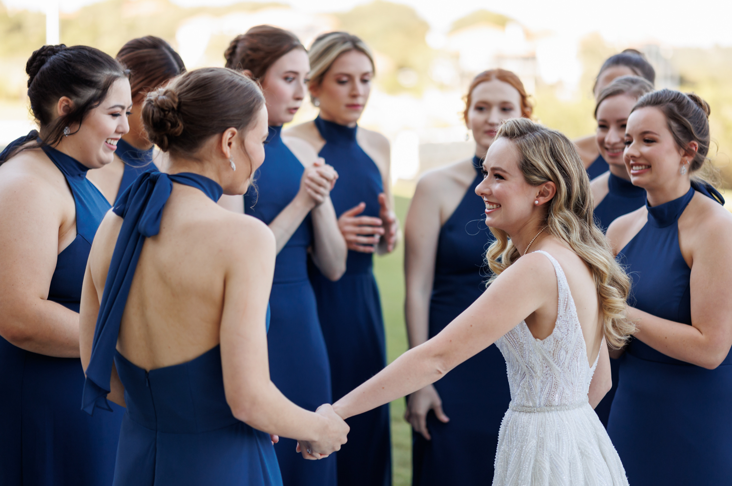 After the bridesmaid reveal, the bride embraces her friends, smiling.