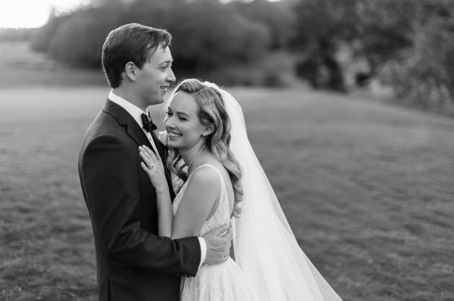 Left: The bride and groom hug and laugh on the golf course during their portraits