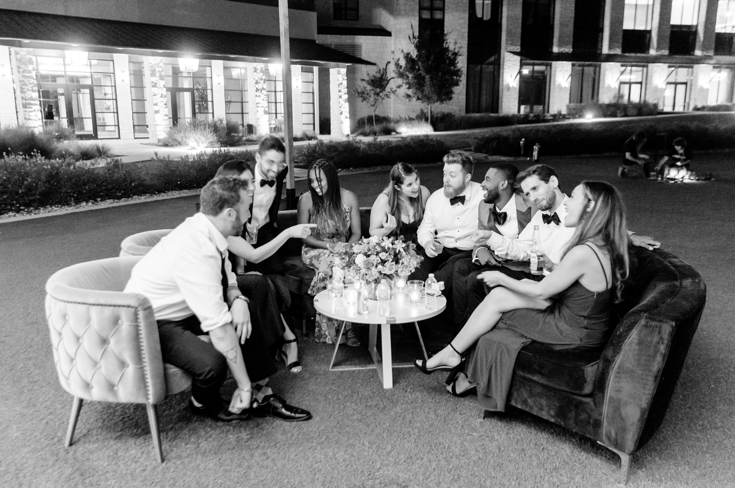 Guests sit at the velvet furniture rentals and chat outside during the reception.