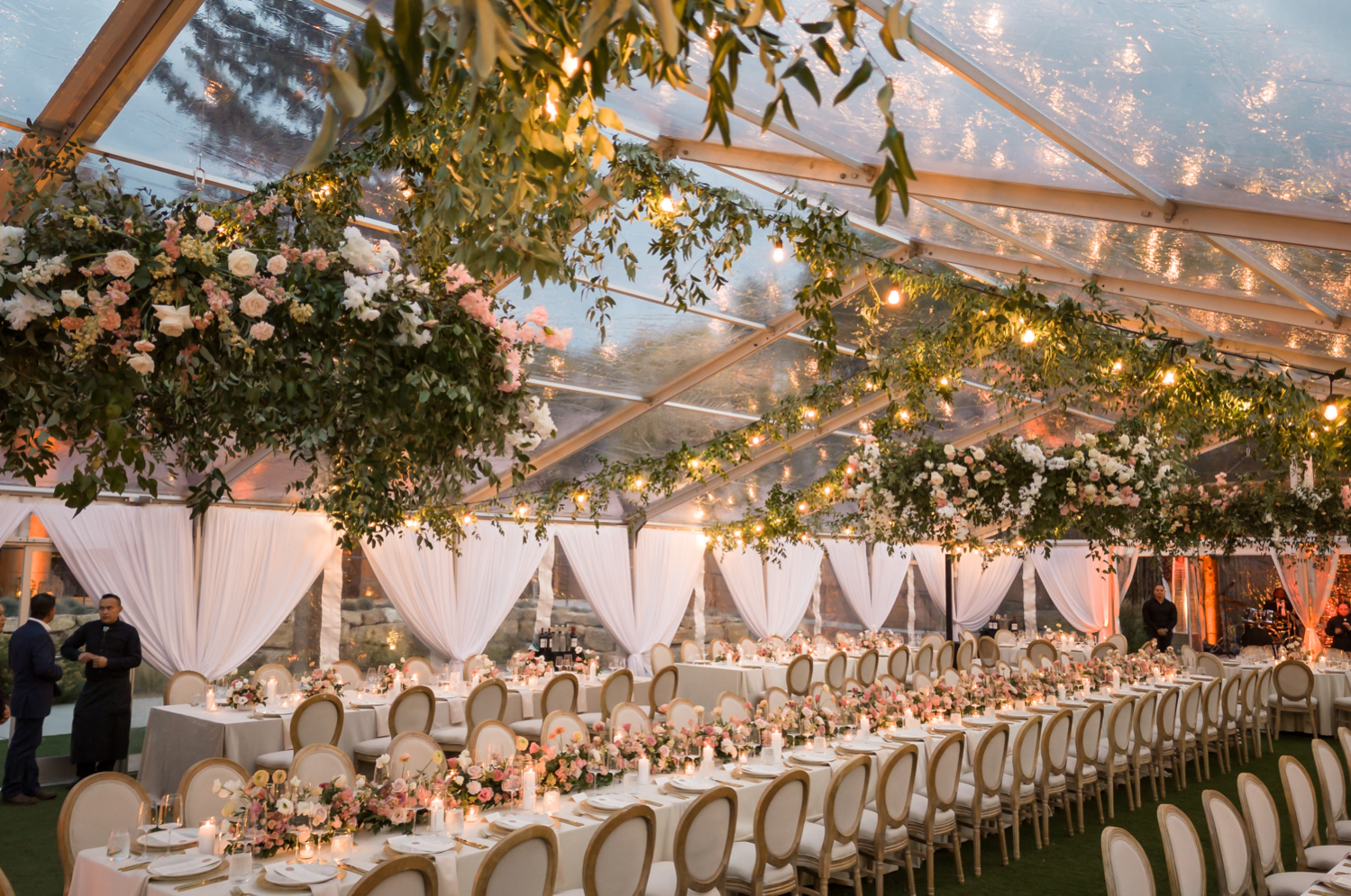 White and pastel florals at the reception with twinkly lights 