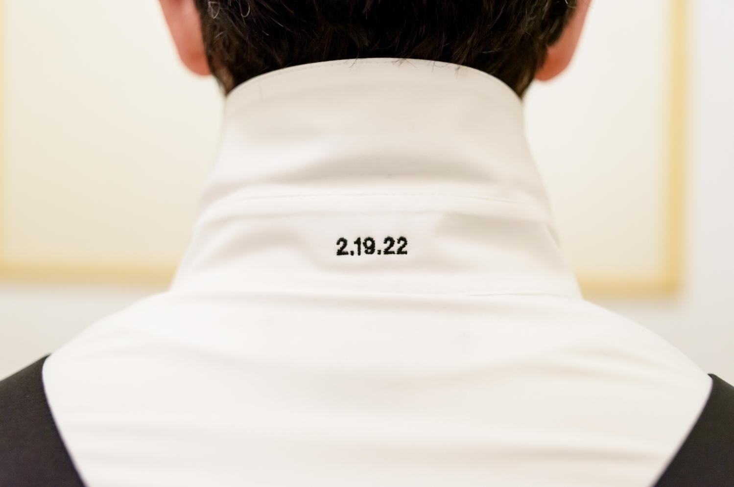 The groom's embroidered dress shirt with his wedding date underneath the collar.