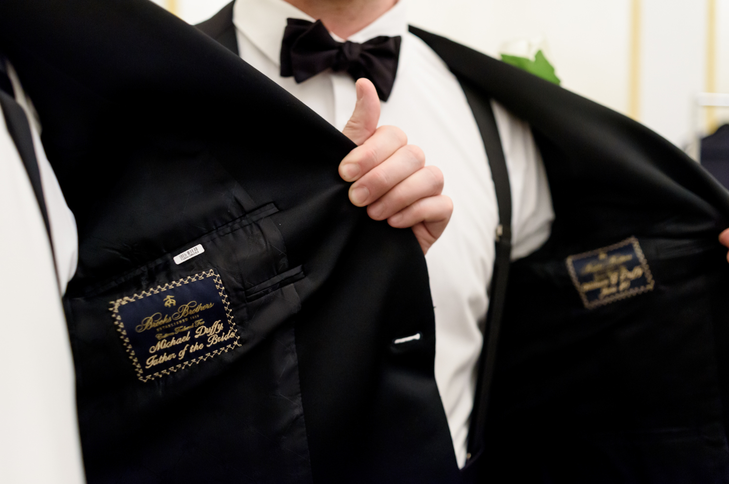 The inside of the father of the bride's suit jacket has been customized with his name and "father of the bride" in gold script.
