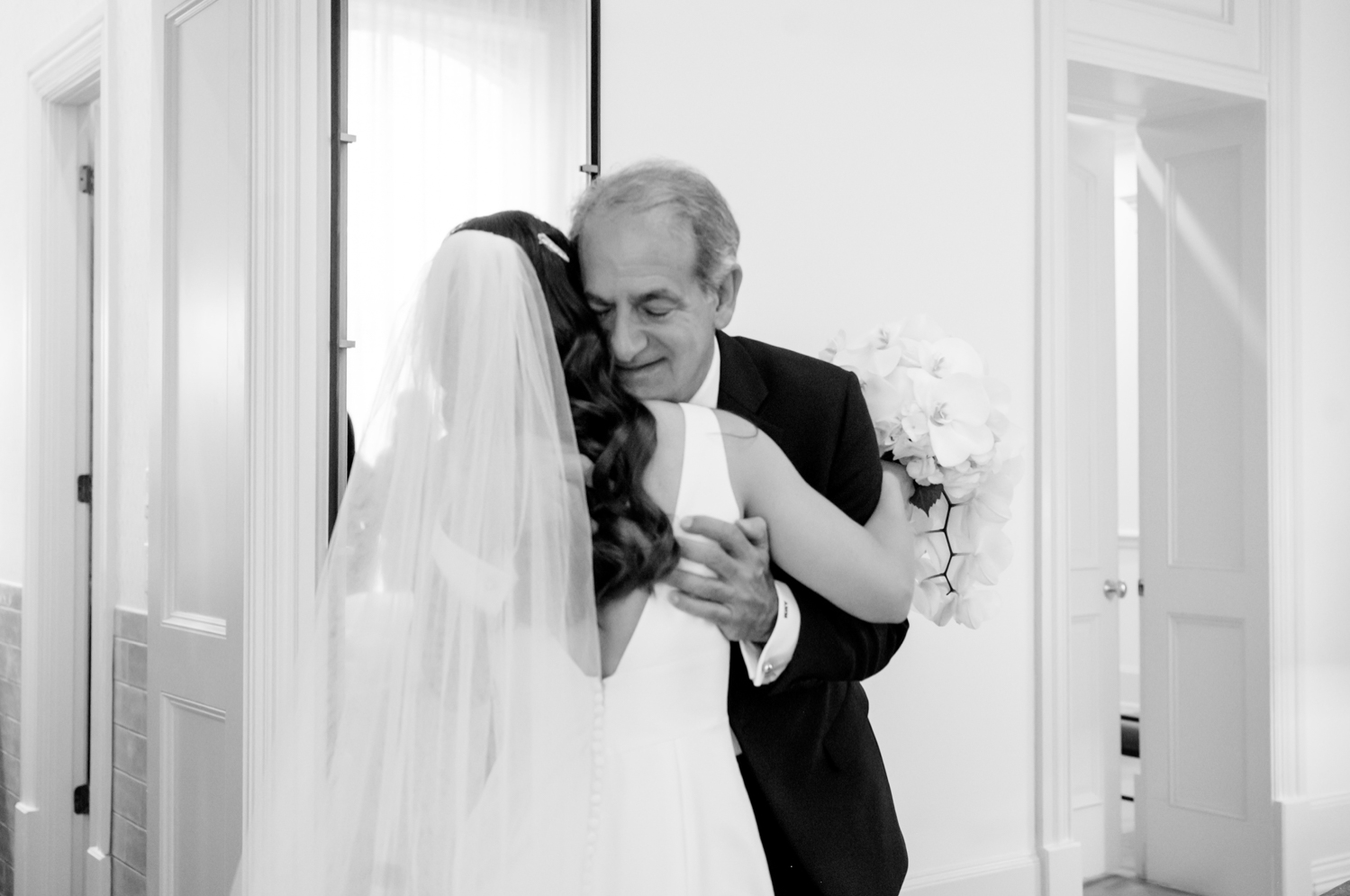The bride hugs her father after he sees her in her dress for the first time.