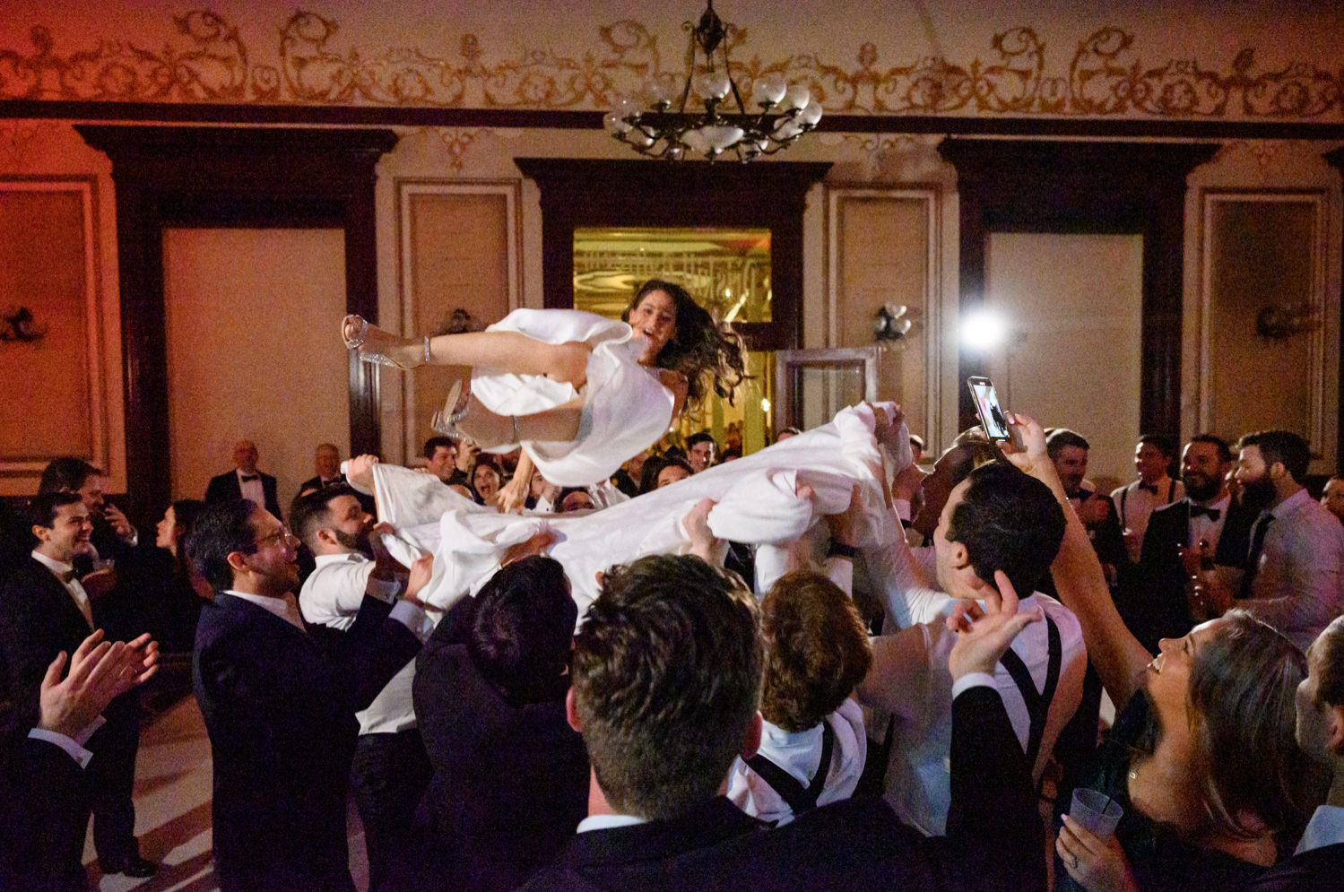 The guests grab a sheet and throw the bride into the air.