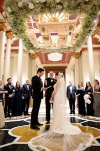 Bride and groom during a wedding ceremony on The Driskill mezzanine