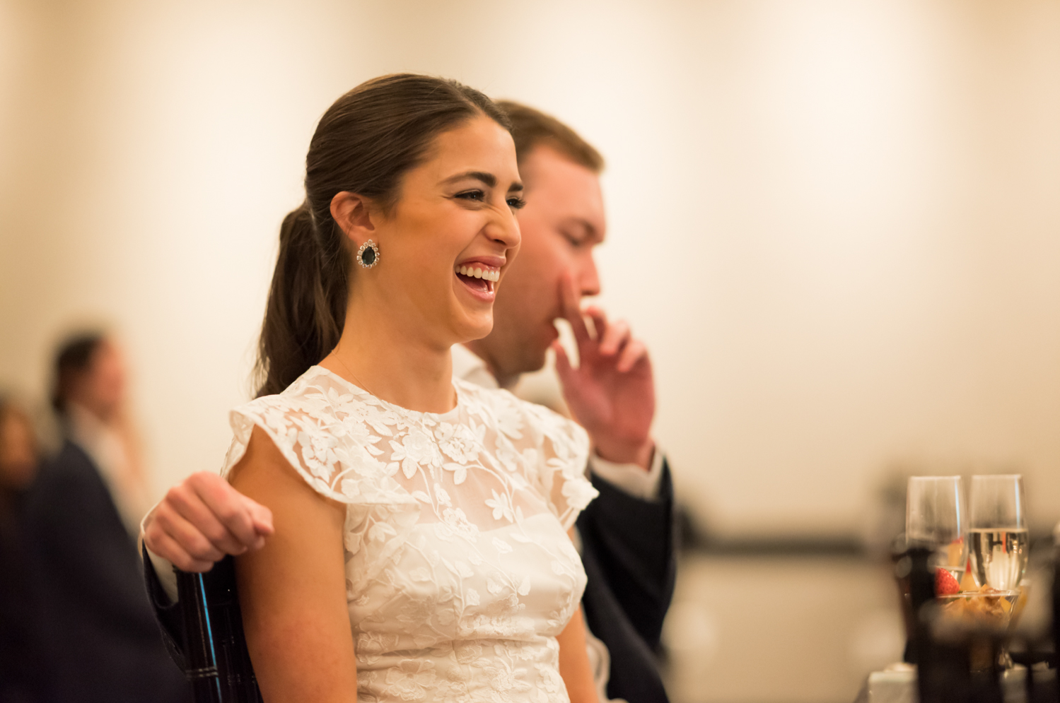 The bride laughs during a toast at the rehearsal dinner.