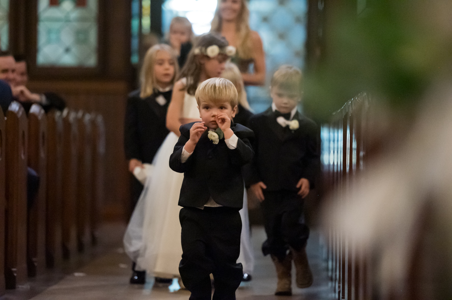 A little boy walks down the aisle with the ring bearers and flower girl.