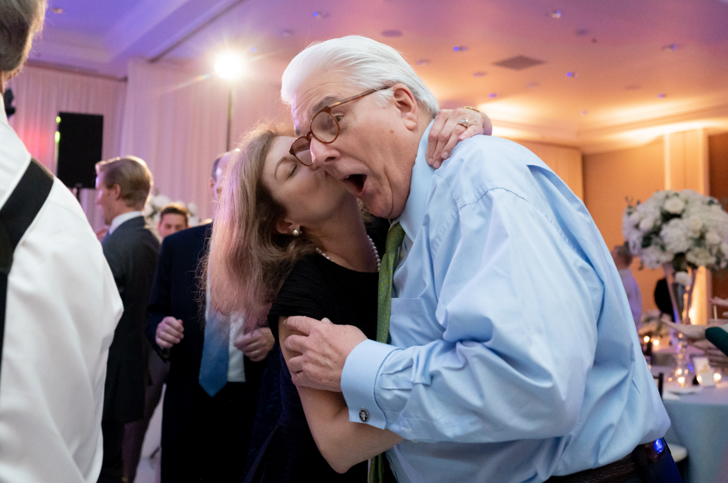 An older couple dances together at the reception.