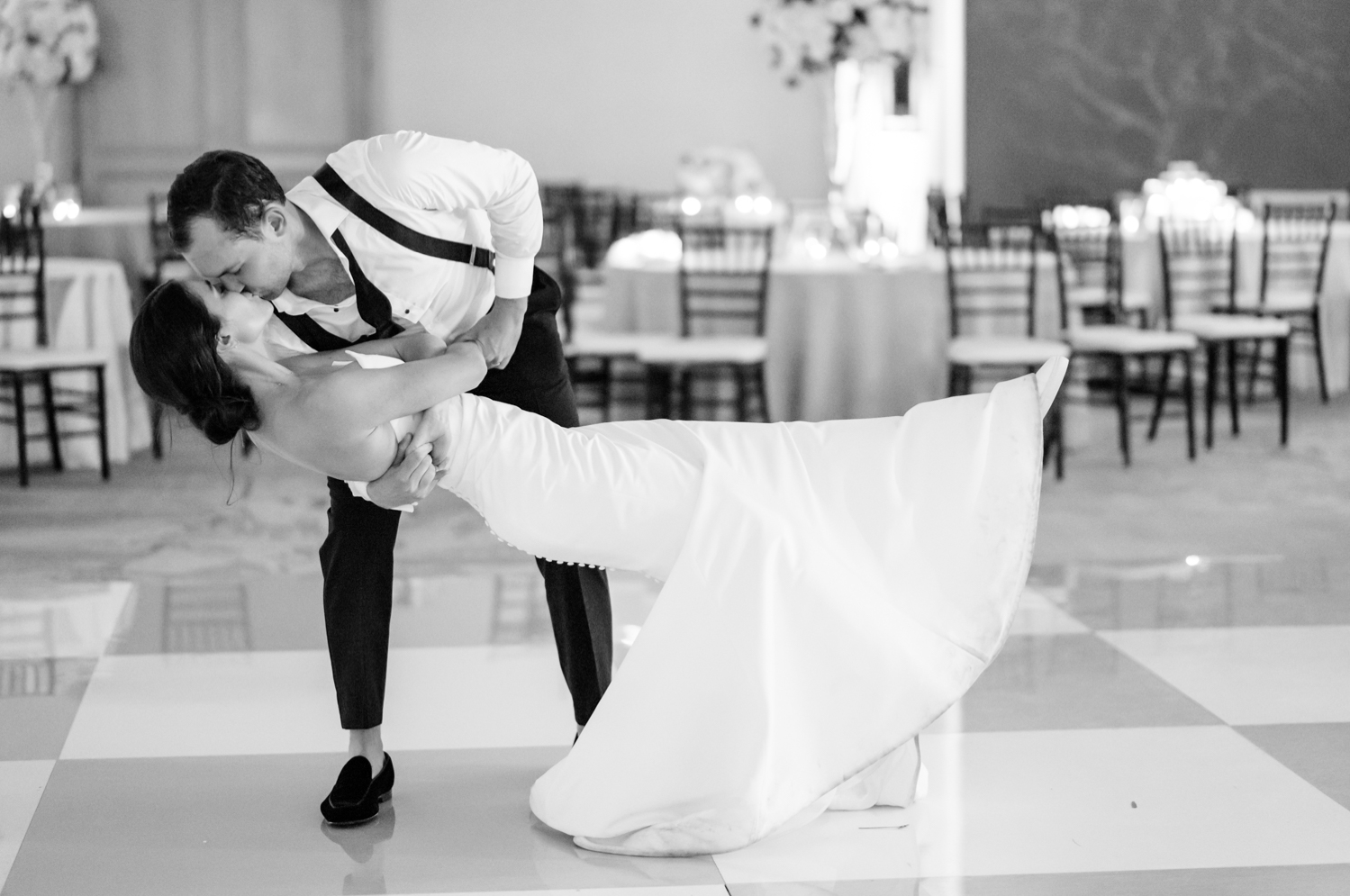 The groom dips his bride and she sticks out her leg, showing off her white sneakers. 