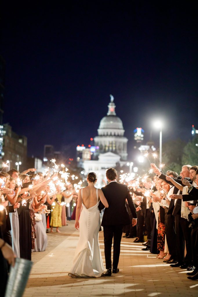 bride and groom exiting the wedding with sparklers in front of the Texas Capitol building