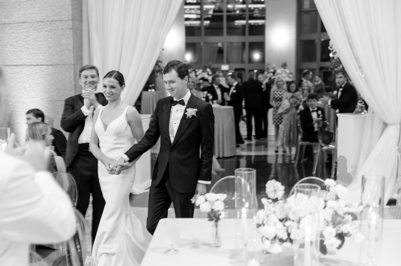 bride and groom walking into the reception