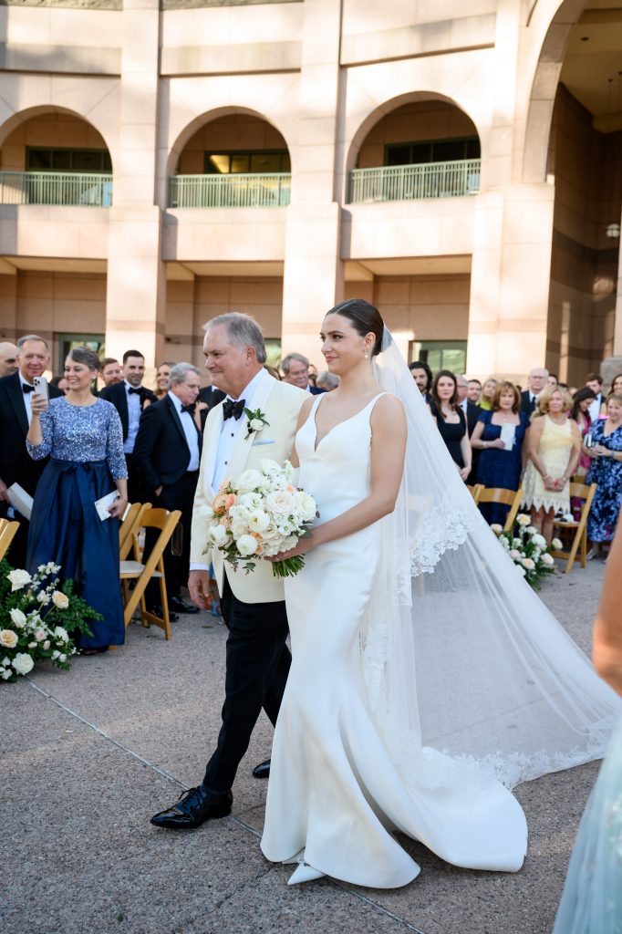 bride being walked down the aisle by her father
