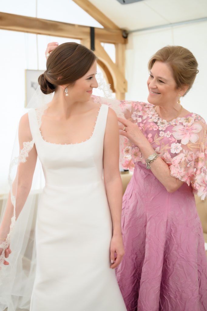 mother of bride helping with bride's veil