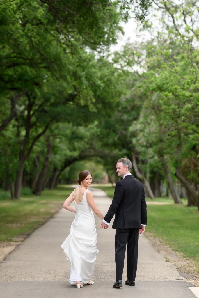 bride and groom holding hands and walking away
