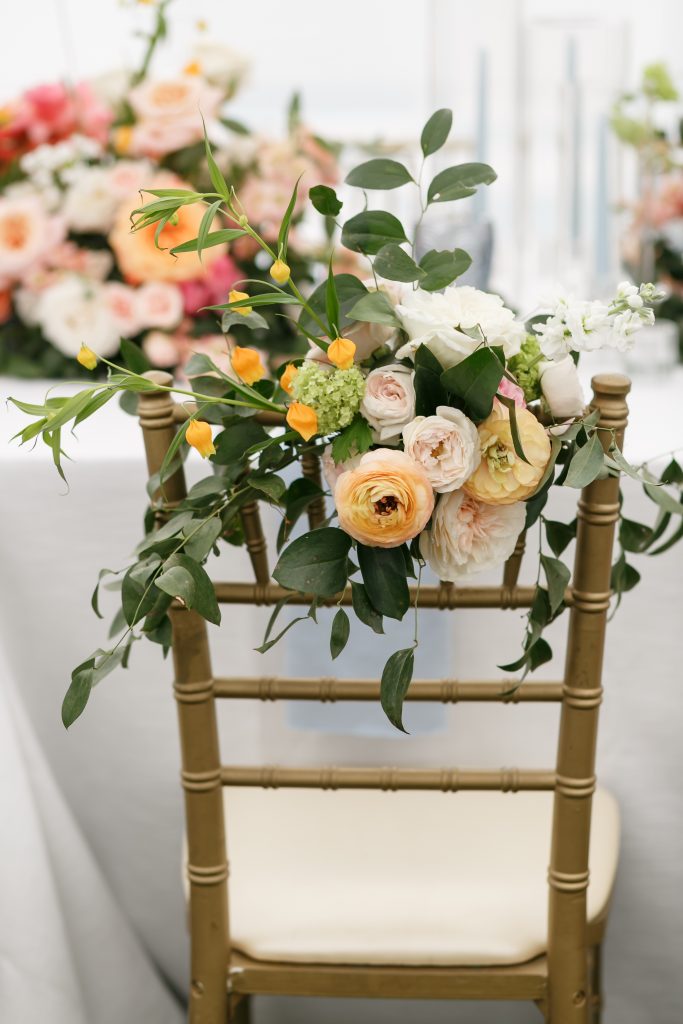pink and orange flowers on back of a gold chair