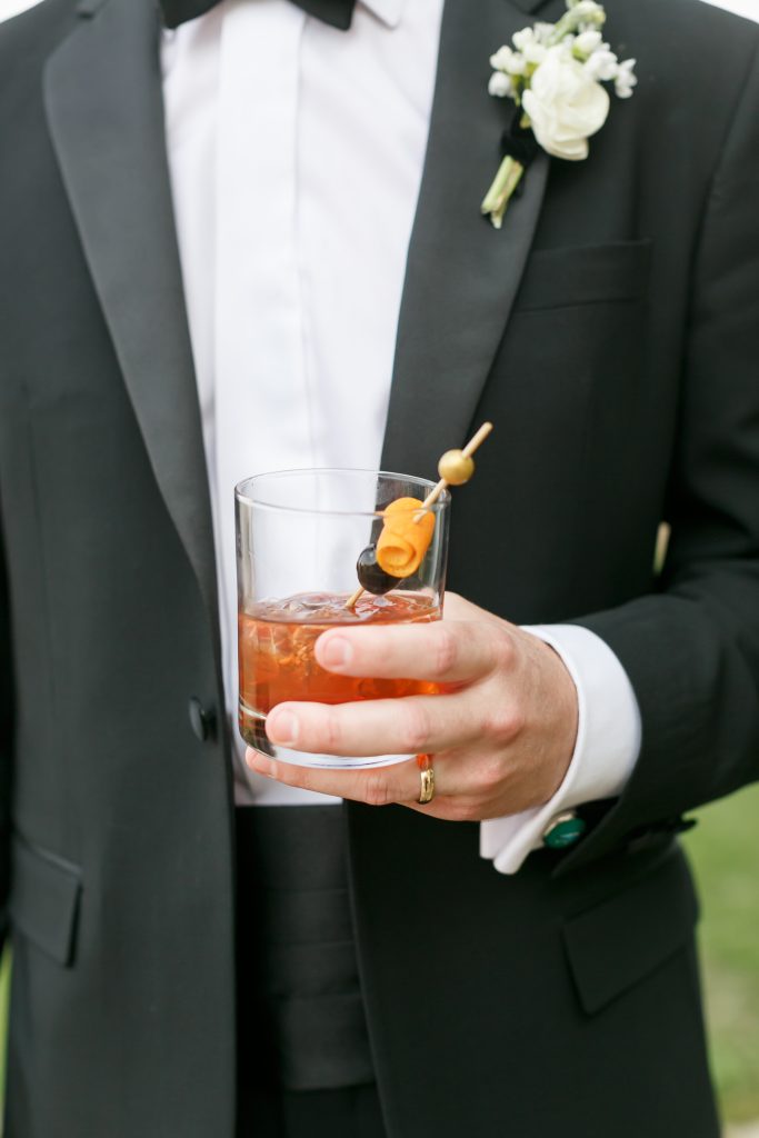 groomsmen holding a whiskey cocktail