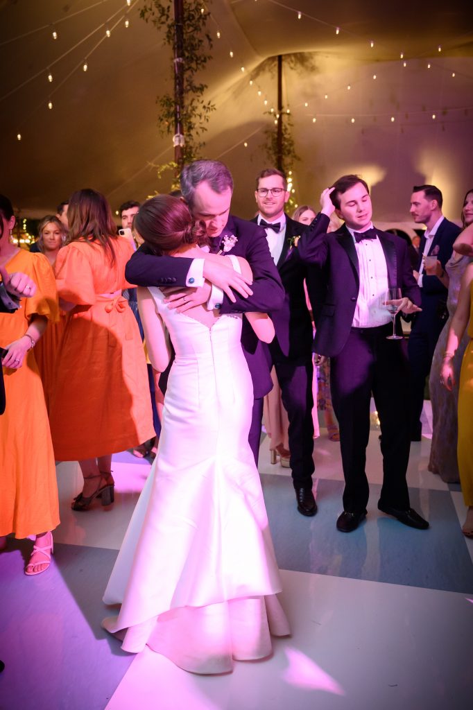 bride and groom hugging in the middle of the dance floor
