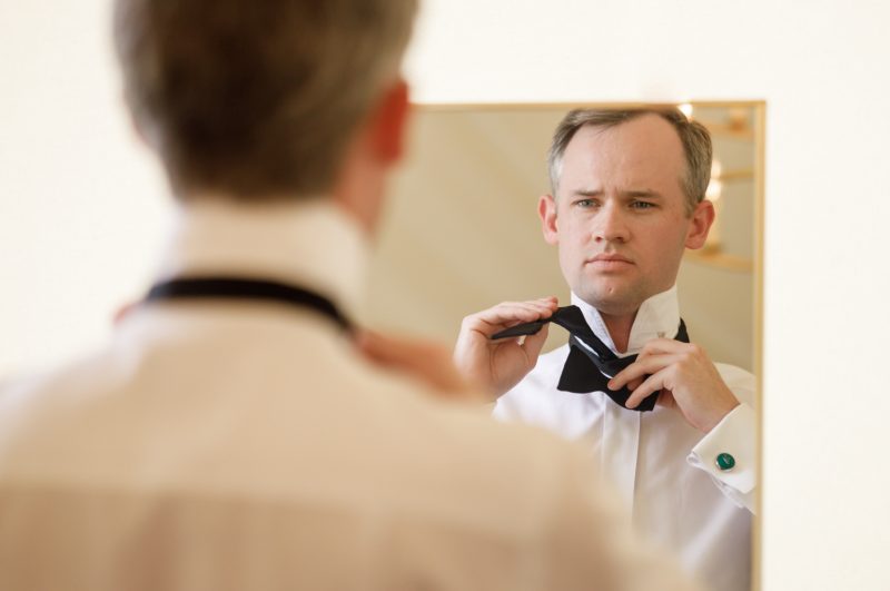 groom putting on his bowtie
