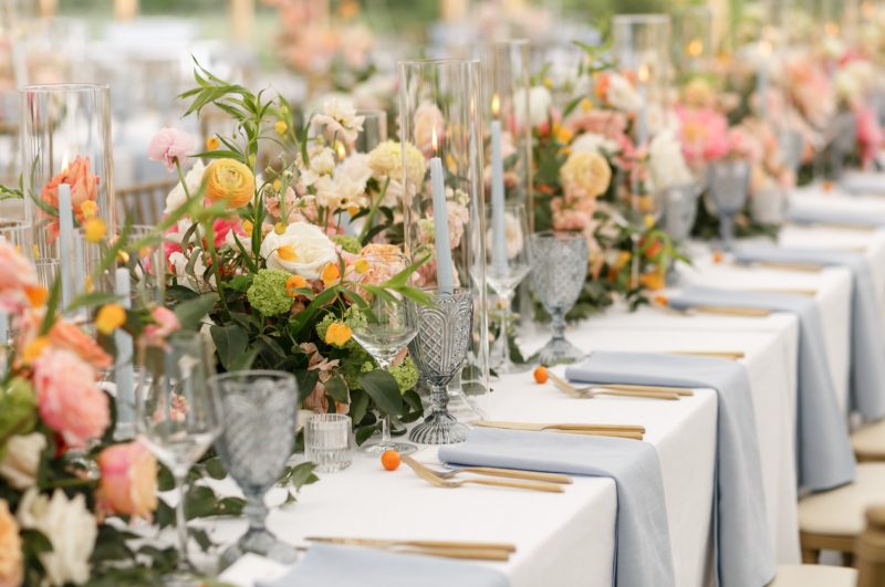 pink and orange floral centerpiece on table with blue pastel accents