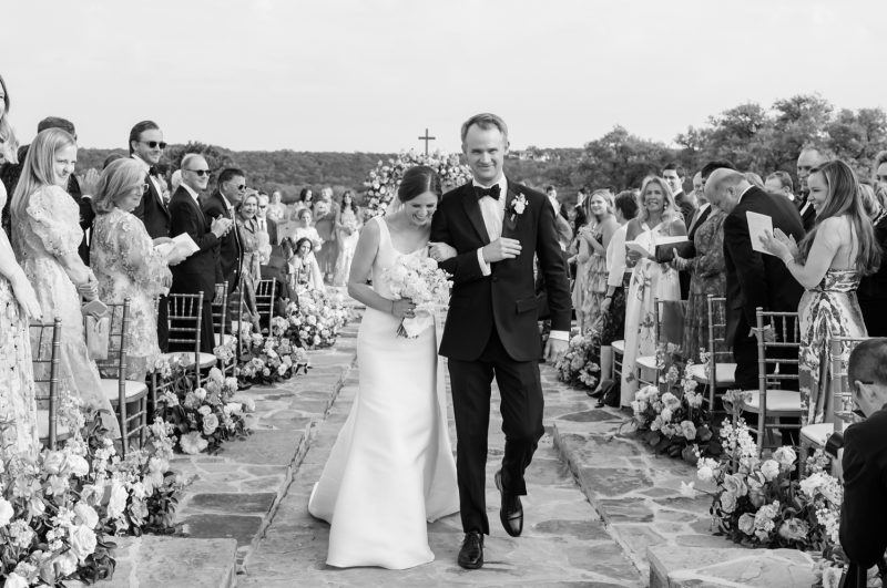 bride and groom hugging as they walk back down the aisle