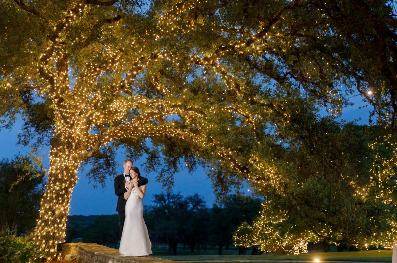 bride and groom portrait under oak tree with shinning lights
