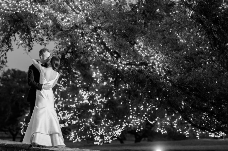 bride and groom kissing under giant oak tree