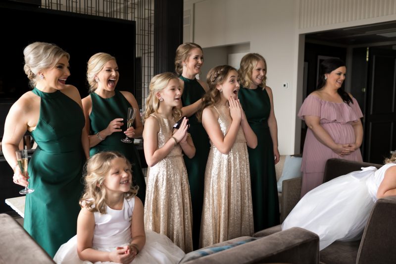 bridesmaids and flower girls seeing the bride in her dress