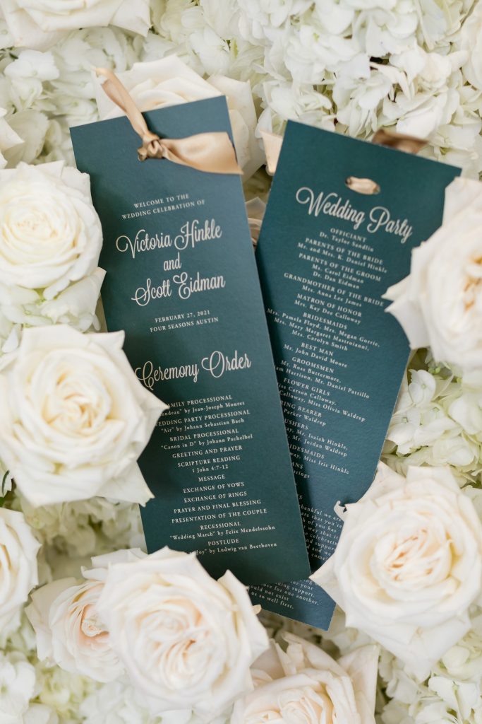 green wedding program with white florals around