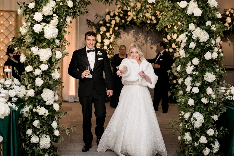 bride and groom walking into the reception