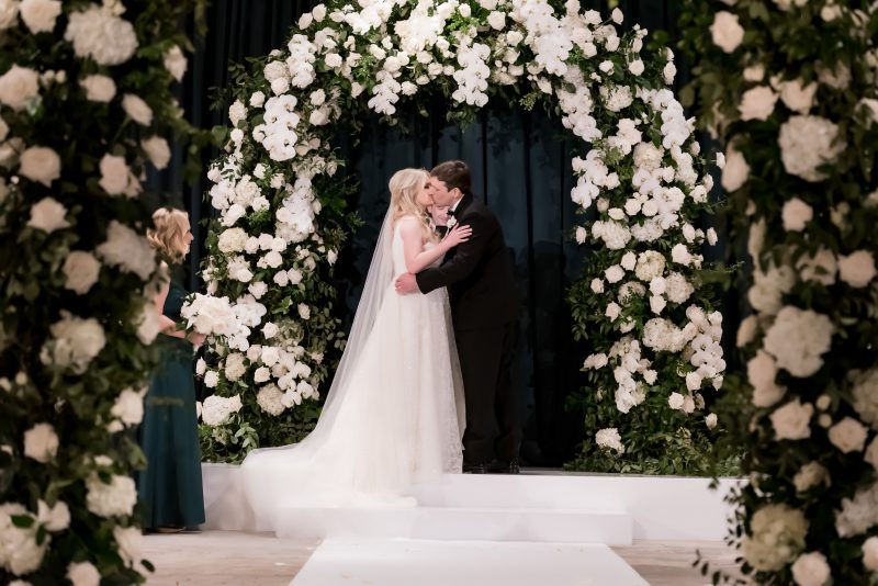 bride and groom kissing at the altar