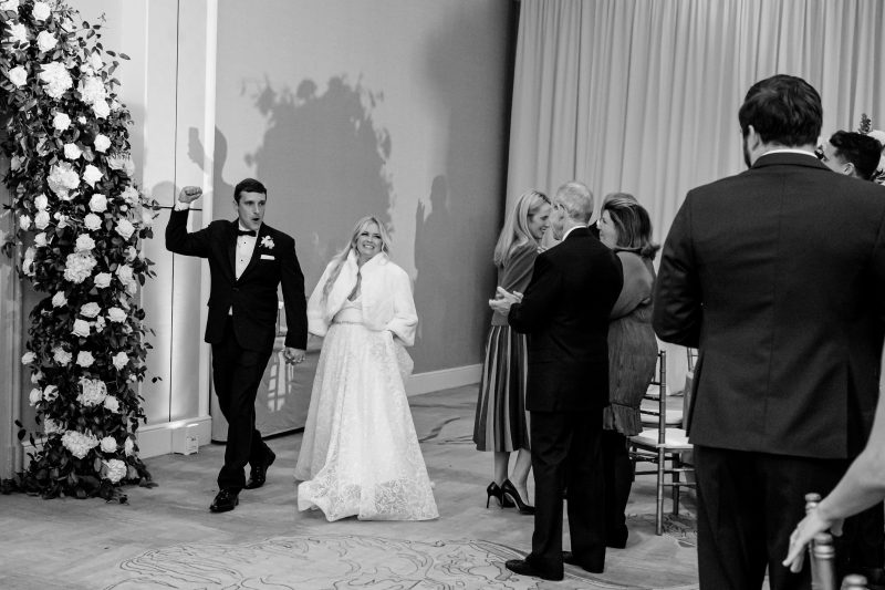 bride and groom walking into the reception