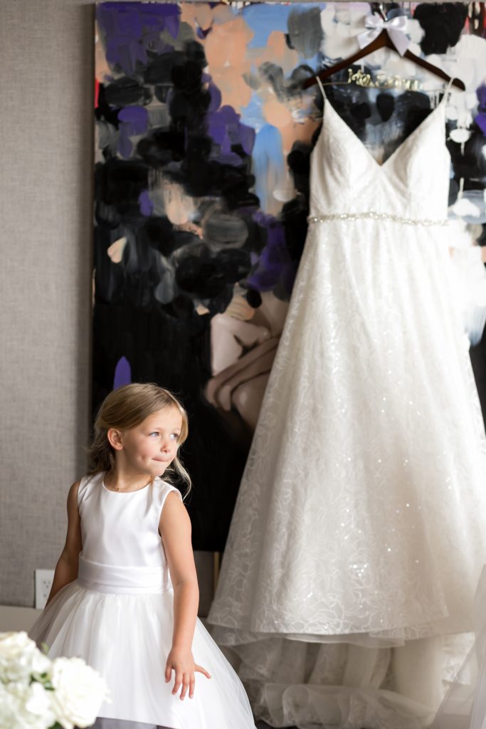 flower girl standing in front of bride's wedding dress