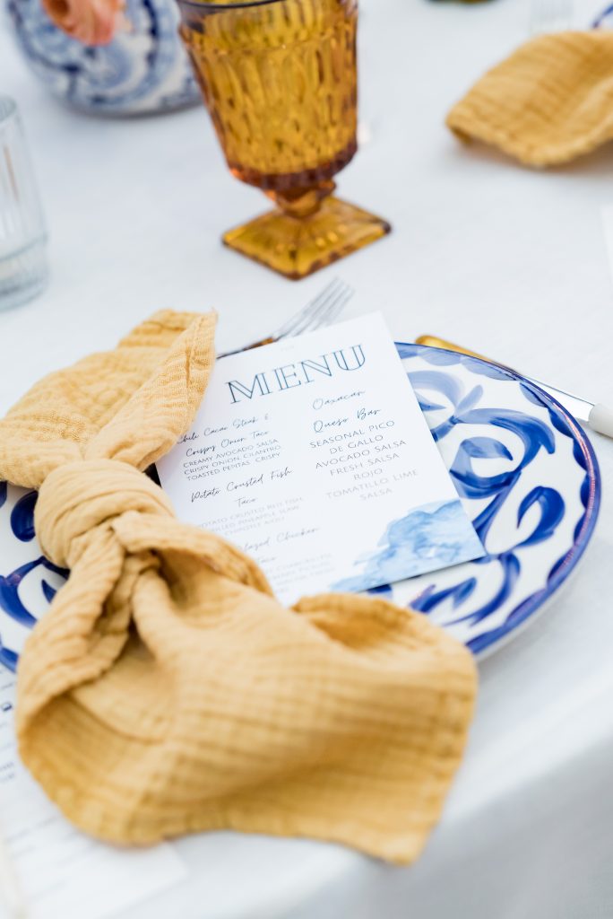 rehearsal dinner menu on blue and white plate with yellow accent napkin