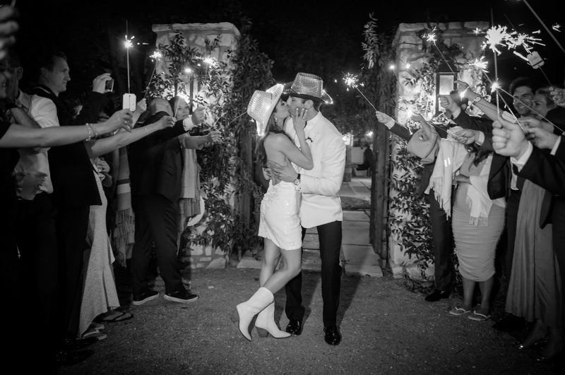bride and groom kissing as they exit the wedding