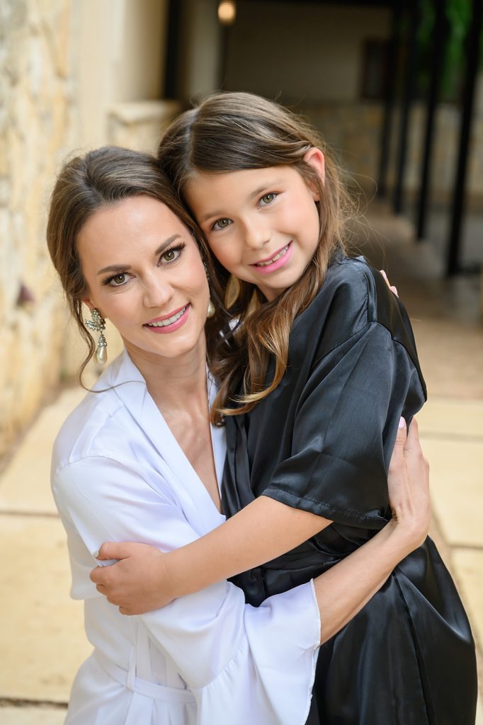 bride and her soon to be step daughter hugging as they get ready