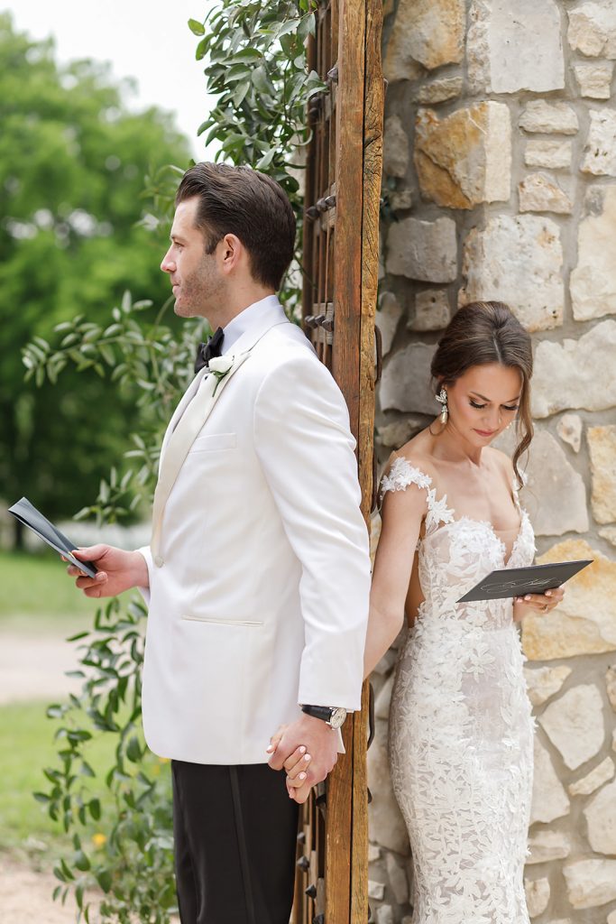 bride and groom reading letters they wrote each other during their first look
