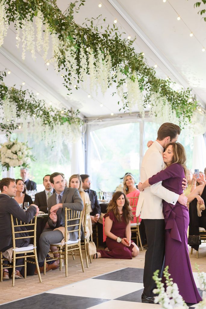 groom dancing with his mother in a purple long sleeve gown