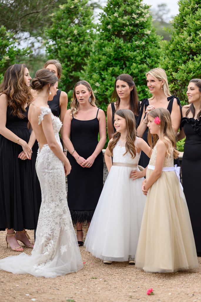 bride showing bridesmaids and flower girls her in her wedding dress