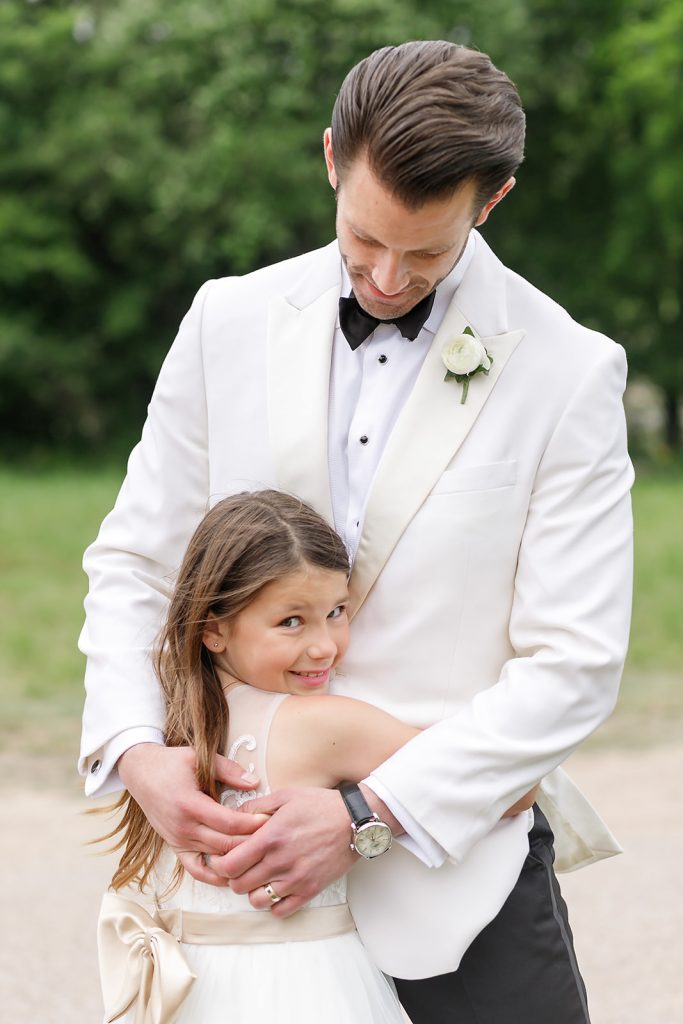 groom hugging his daughter, the flower girl