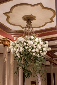 Large white floral arrangement on The Driskill mezzanine beneath a historic chandelier