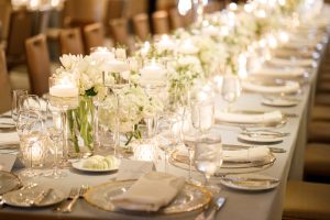 White floral centerpiece and place setting during a wedding reception at The Driskill