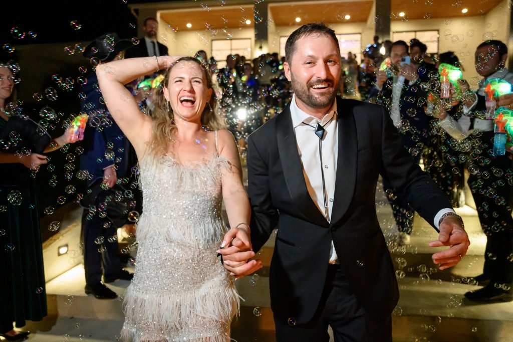Bride and groom laughing as they run their their bubble exit at the Arlo