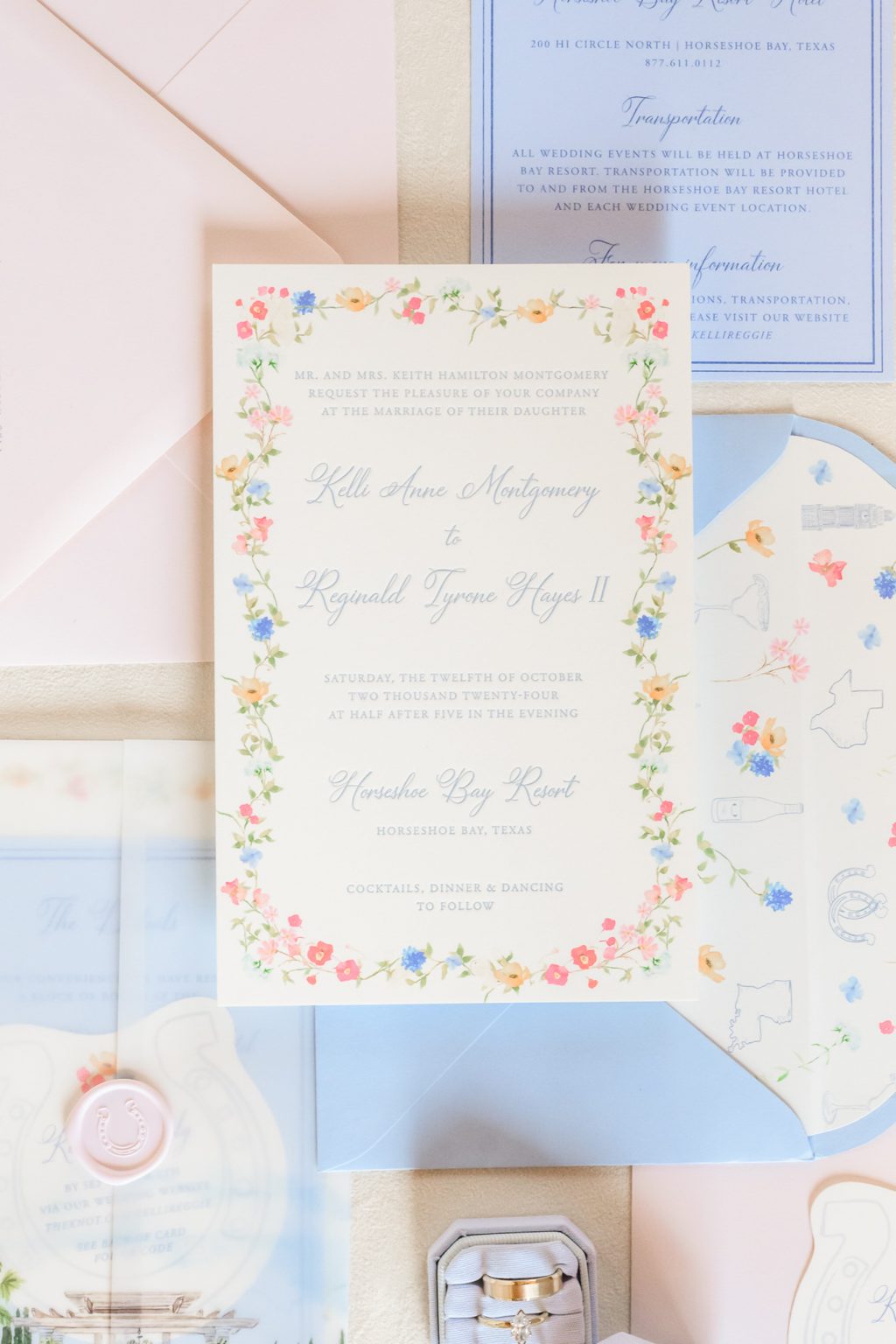 A beautifully styled flat lay of Kelli and Reggie's wedding invitation suite, featuring delicate calligraphy, soft floral accents, and elegant stationery elements.