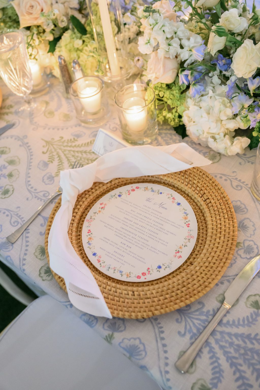 A close-up of the wedding table adorned with gold-rimmed china, soft candlelight, and lush floral arrangements in shades of pink and ivory, creating a romantic ambiance.