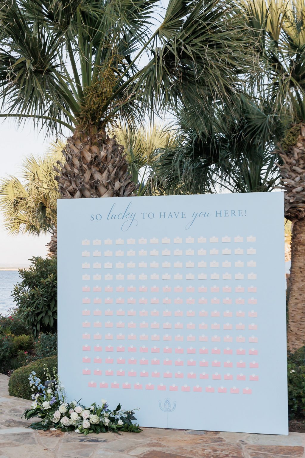 A custom wedding sign with elegant blue calligraphy, incorporating the couple’s bespoke wedding crest and personal touches.
