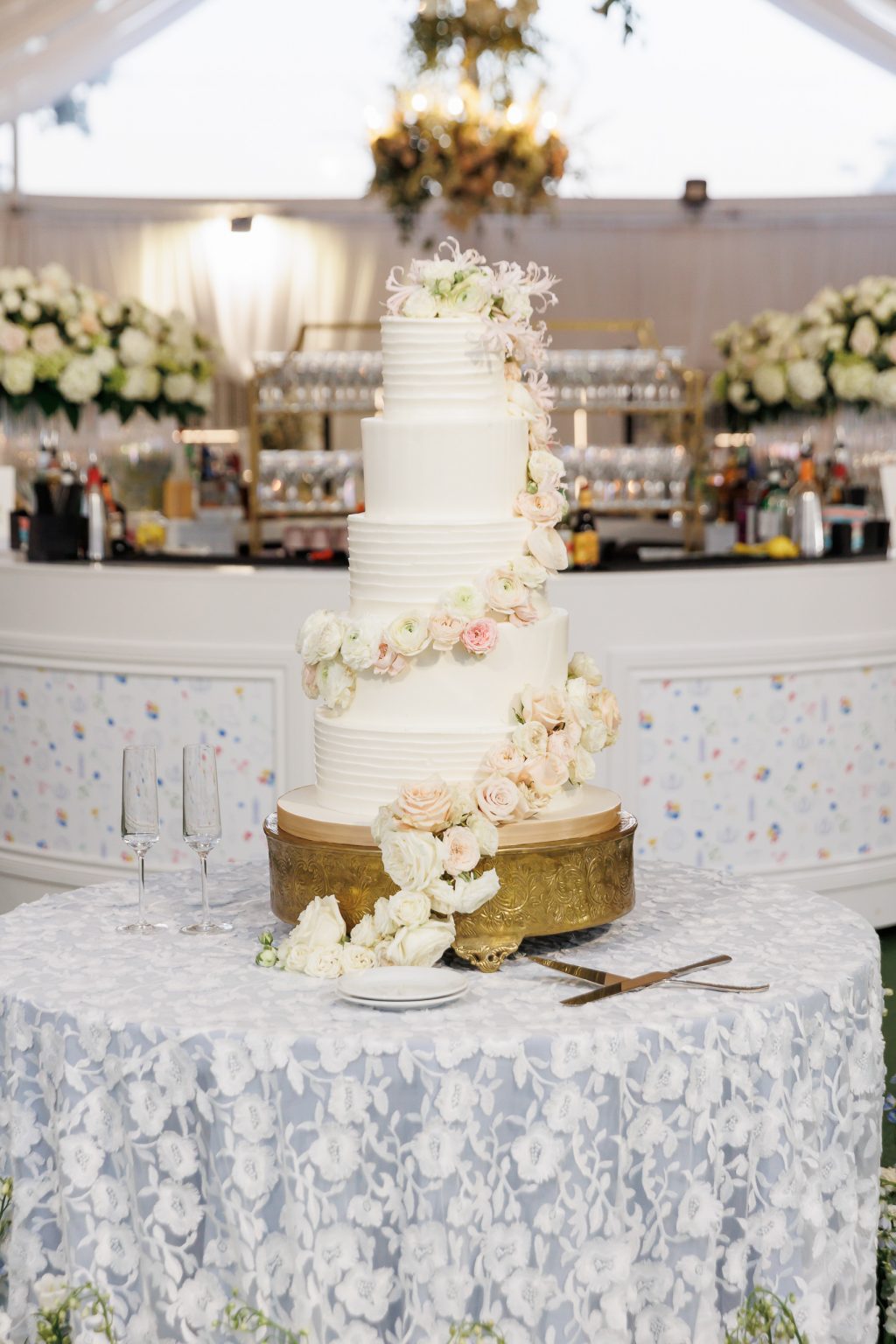 A close-up of the couple’s Simon Lee Bakery wedding cake, adorned with blush pink roses and delicate sugar detailing.