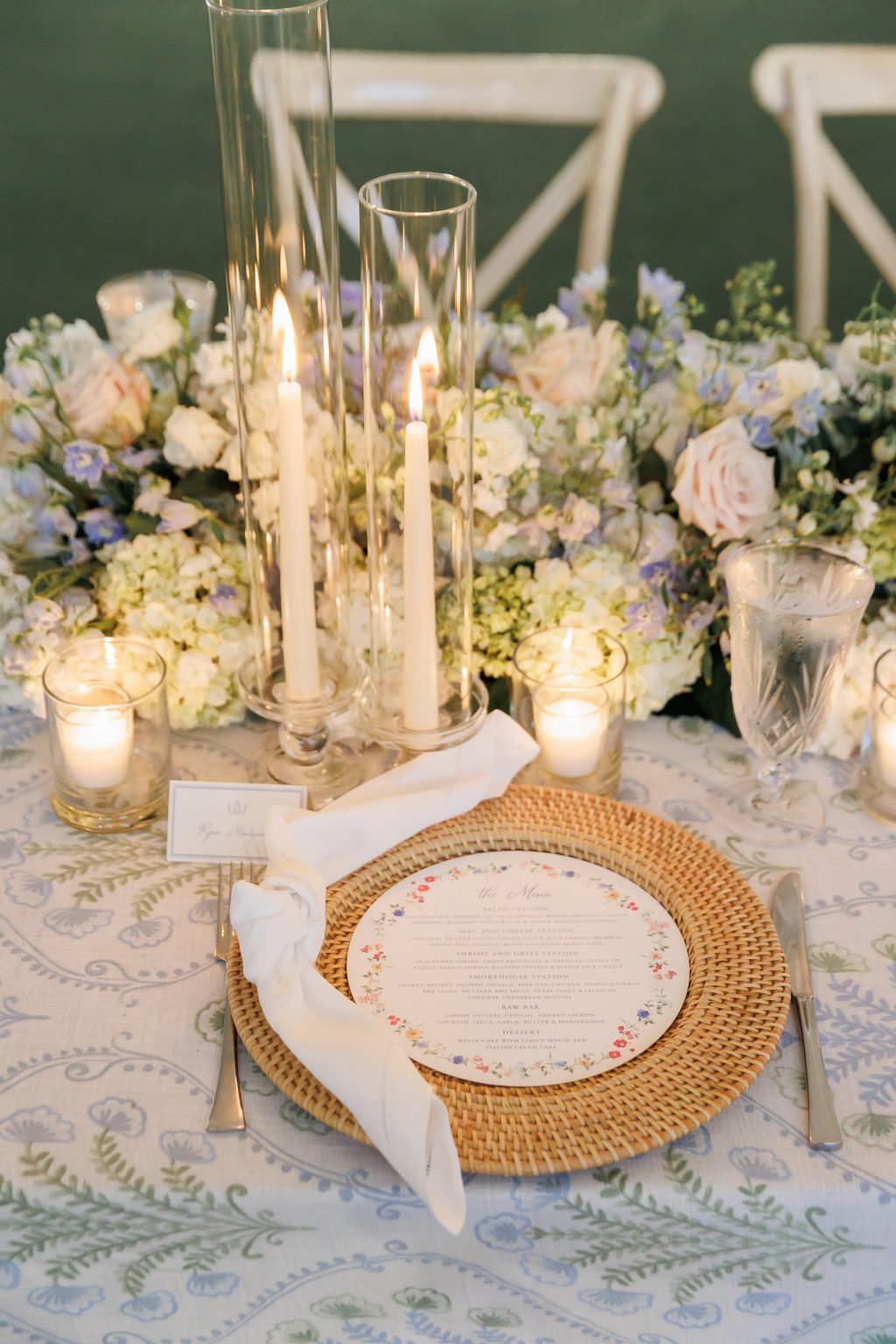 A refined reception table setting featuring floating candles, delicate floral arrangements, and gold accents, elegantly styled in the waterfront ballroom at Horseshoe Bay Resort.