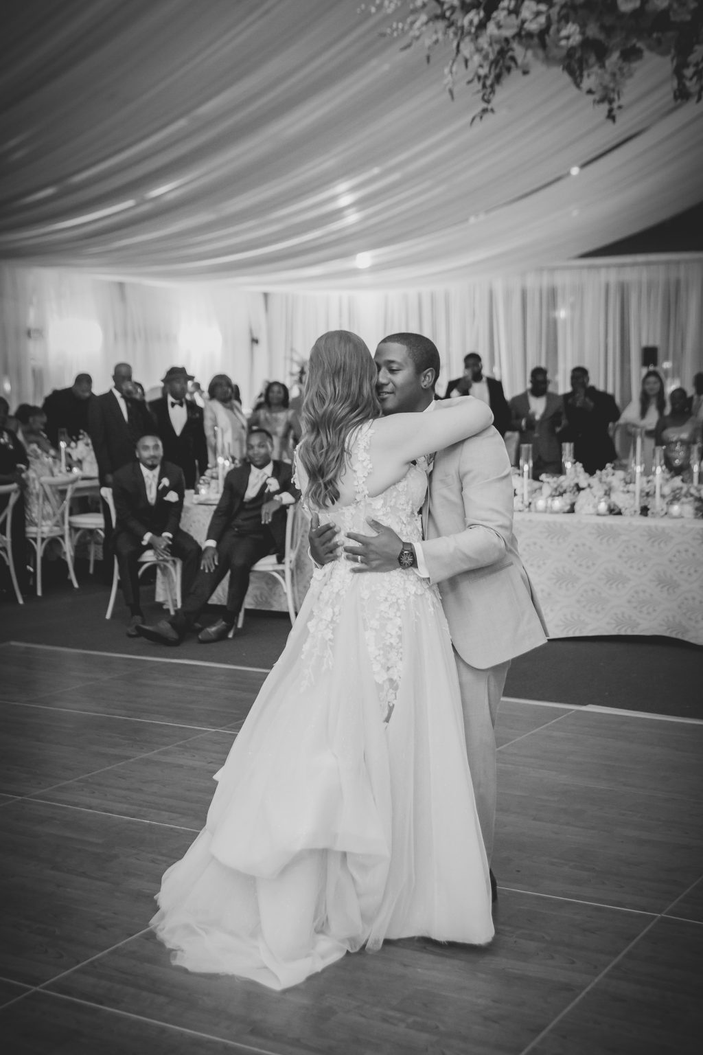 The bride and groom sharing their first dance beneath the elegantly draped tent at Horseshoe Bay Resort, surrounded by friends and family.